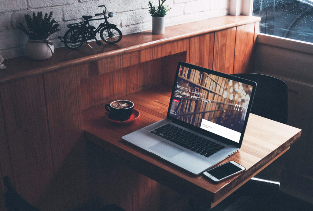 laptop on wooden table, with cup of coffee and mobile phone