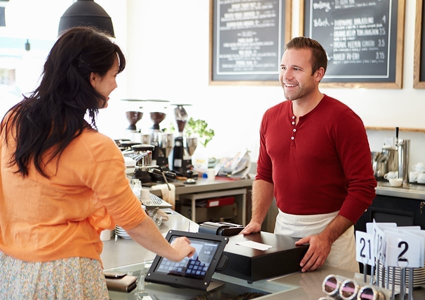 Man in red shirt serving at a cafe counter